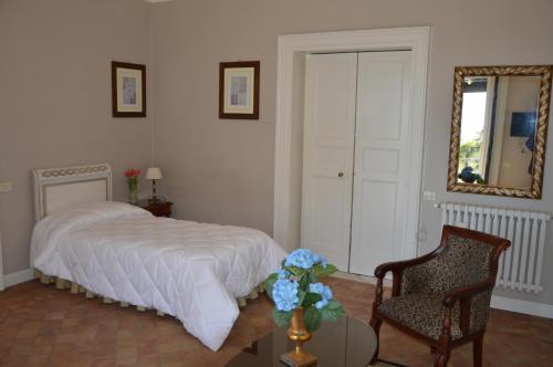 a bedroom with a bed and a chair and a mirror at Le stanze dei Mori - quadrupla con bagno privato in Mascalucia