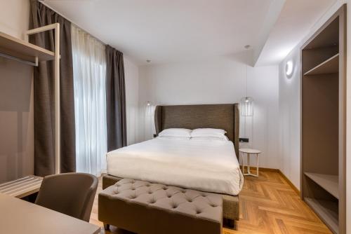 a bedroom with a bed and a table and chairs at Mercure Roma Centro Termini in Rome