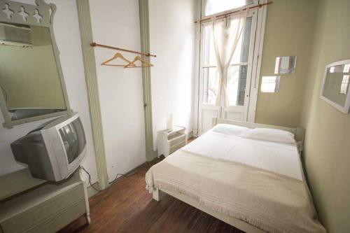 1 dormitorio con 1 cama, TV y ventana en Hostel Point en Rosario