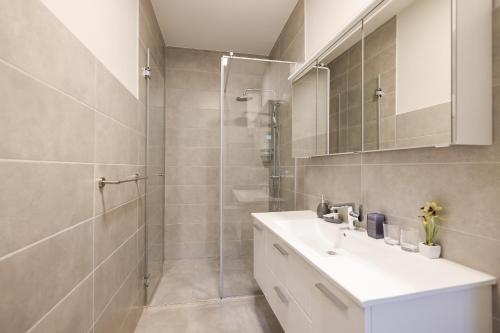 a bathroom with a sink and a shower at Elegance Studio Apartments in Zadar