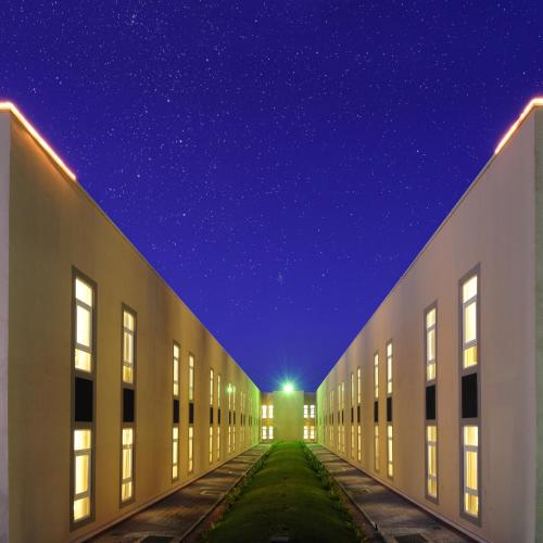 a row of buildings at night with a starry sky at City Hotel Duqm in Duqm