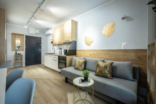 sala de estar con sofá azul y cocina en WiguryTower Apartaments 74', en Łódź