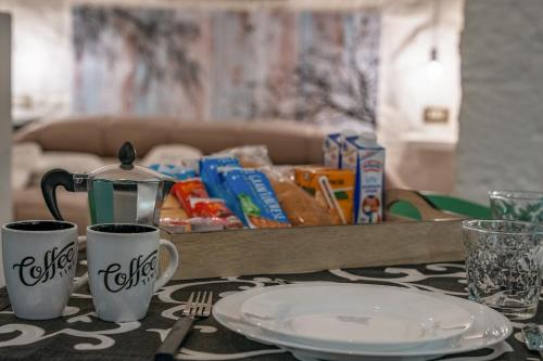 una mesa con dos tazas de café y un plato en ella en Casa Vacanze “House on the Left”, en Ceglie Messapica