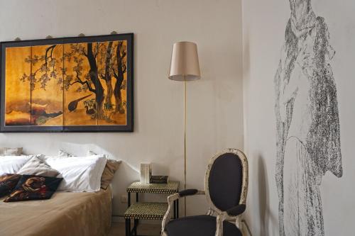 - une chambre avec un lit, une chaise et un tableau dans l'établissement Dimora Capuleti, à Vérone