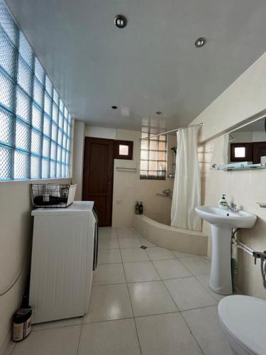 La salle de bains est pourvue d'une baignoire, d'un lavabo et de toilettes. dans l'établissement Guest House Anuki, à Sighnaghi