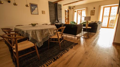 un salon avec une table, des chaises et un canapé dans l'établissement Chalet Peak Noir entier 12pers - Cosy House Peak Noir for 12people, au Monêtier-les-Bains