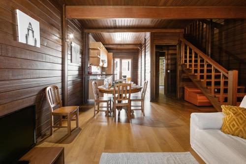 a living room with a table and chairs and a staircase at Stylish Rustic Villa in Vau