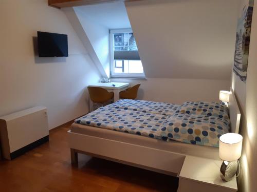 ein kleines Schlafzimmer mit einem Bett und einem Schreibtisch in der Unterkunft Ferienhaus Würzgarten in Ürzig