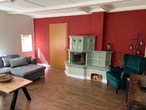 a living room with a couch and a fireplace at Wellness & Wirlpool-Oase am Wald - Waldferienhaus Dunja in Oybin in Hain