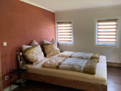 a bedroom with a bed with pillows on it at Wellness & Wirlpool-Oase am Wald - Waldferienhaus Dunja in Oybin in Hain