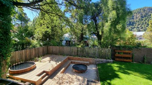 un patio trasero con una valla de madera y una hoguera en Haus del Arroyo - Andarlibre en San Martín de los Andes