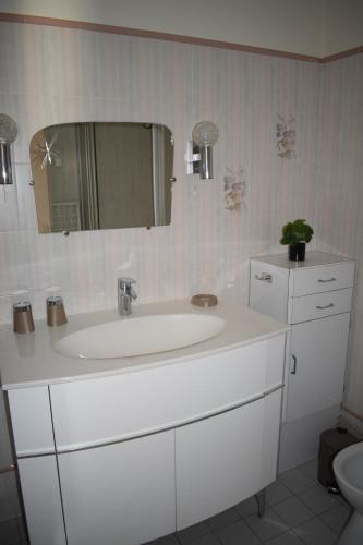 een badkamer met een witte wastafel en een spiegel bij Côte et Vie - appartement et garage in Saint-Gilles-Croix-de-Vie