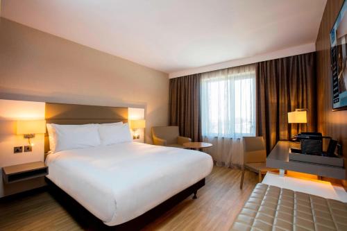 a hotel room with a large bed and a desk at AC Hotel by Marriott Manchester Salford Quays in Manchester