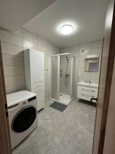een badkamer met een douche en een wasmachine bij Pension u Vlčků in Hracholusky