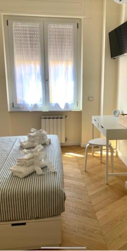 a bedroom with a bed and a desk and windows at Little House 5 Terre in La Spezia