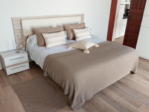 Un dormitorio con una cama grande con almohadas. en Casita Los Celajes, en La Guancha