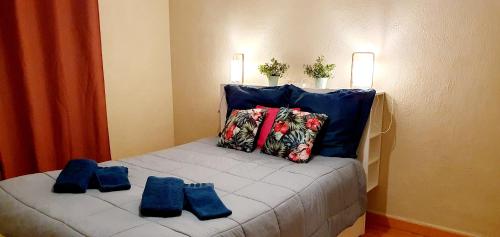 a bed with blue pillows on top of it at Le Bienvenue à Colmar - Parking Privé Inclus, Centre à Deux Pas in Colmar