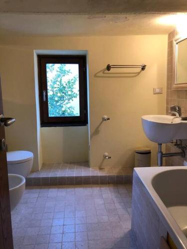 La salle de bains est pourvue d'un lavabo, de toilettes et d'une fenêtre. dans l'établissement Casa Luci, vista mare, à Vezzi Portio