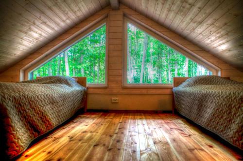 two beds in a room with a large window at Villa Pillapalu in Pillapalu