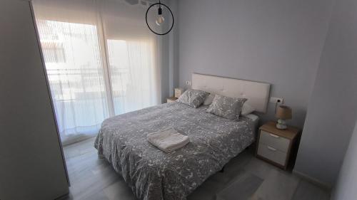 une chambre avec un lit et une grande fenêtre dans l'établissement Apartamentos La Casa de Bebita, à Fuengirola