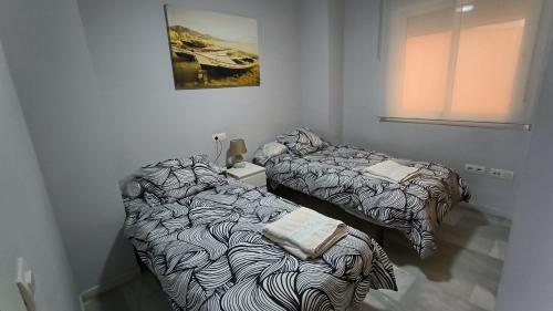 2 Betten nebeneinander in einem Zimmer in der Unterkunft Apartamentos La Casa de Bebita in Fuengirola