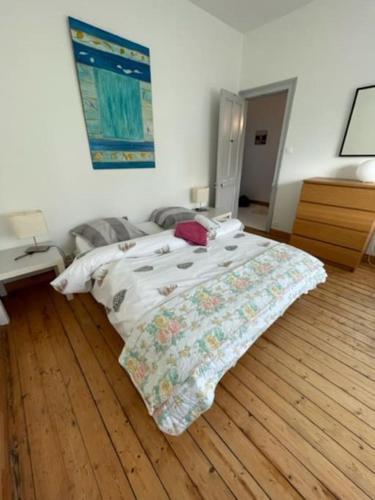 a bedroom with a bed and a wooden floor at Grande maison proche mer, centre Wimereux in Wimereux