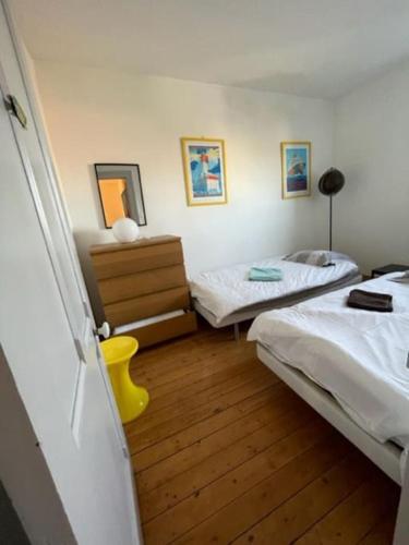 une chambre avec deux lits et un parquet dans l'établissement Grande maison proche mer, centre Wimereux, à Wimereux