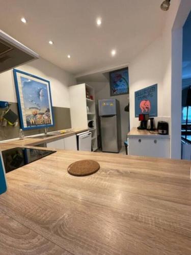 - une cuisine avec un comptoir en bois et une table en bois dans l'établissement Grande maison proche mer, centre Wimereux, à Wimereux