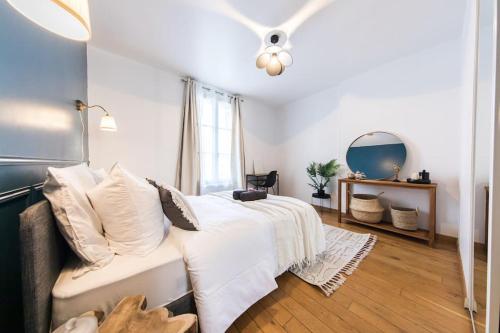 une chambre avec un lit blanc et un miroir dans l'établissement Appartement lumineux 2 chambres Coeur de Tours, à Tours
