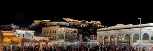 a crowd of people standing in front of buildings at night at Clyde Athens by Nin&Bau in Athens