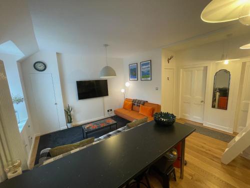 uma sala de estar com um sofá e uma mesa em Glen Ness Apartment in tranquil area of city centre em Inverness