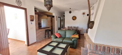 ein Wohnzimmer mit einer grünen Couch und einem Kamin in der Unterkunft Casa Antonia in Zahora