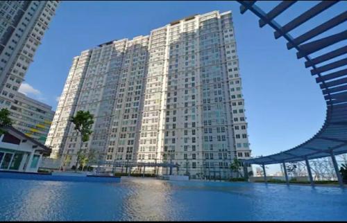 a large white building with a reflection in the water at San Lorenzo place condo in Manila