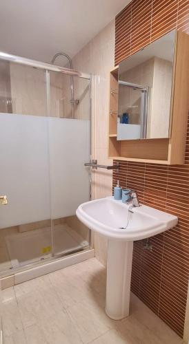 ein Badezimmer mit einem weißen Waschbecken und einer Dusche in der Unterkunft Apartamento a 2 minutos de la playa y centro in Fuengirola