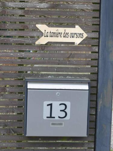 a clock on a wall with a sign on it at La tanière des oursons in Aywaille