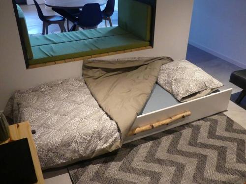 a bed in a room with a mirror on the wall at La tanière des oursons in Aywaille