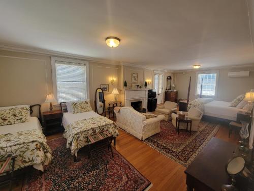 a living room with two beds and a fireplace at Hornsby House Inn in Yorktown