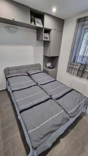a bed in a room with three mattresses at HT Apartman in Mezőkövesd