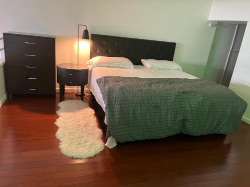 1 dormitorio con cama, mesa y alfombra en Full loft-style apartment near Omni, en New Haven