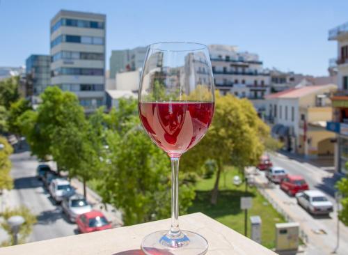una copa de vino tinto sentada en una cornisa en M City Hotel, en La Canea