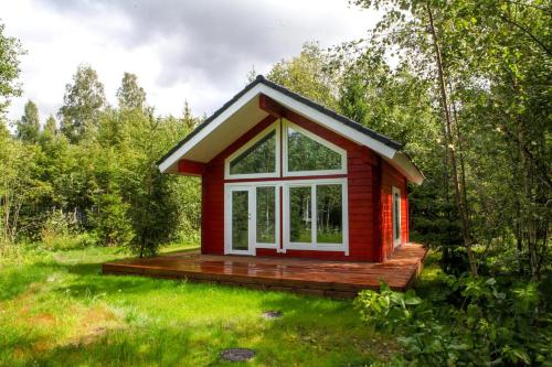 a red tiny house in the middle of a field at Villa Pillapalu in Pillapalu
