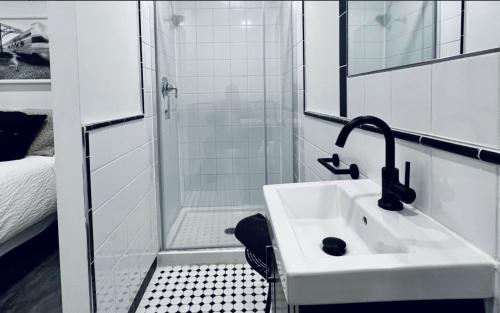 a white bathroom with a sink and a shower at L'Hotel Particulier Griffintown in Montréal