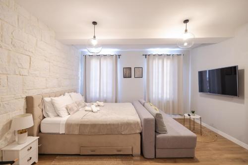 a bedroom with a large bed and a flat screen tv at Elegance Studio Apartments in Zadar