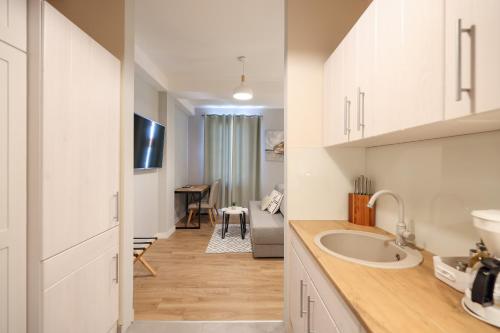 a kitchen with a sink and a living room at Elegance Studio Apartments in Zadar