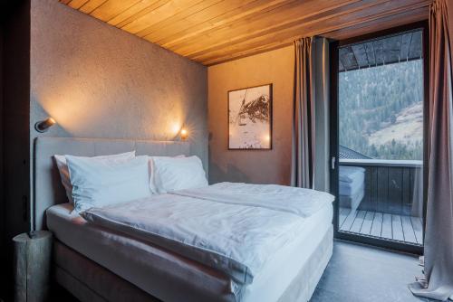 - une chambre avec un lit et une grande fenêtre dans l'établissement Paznauner Villen - Villa I, à Kappl