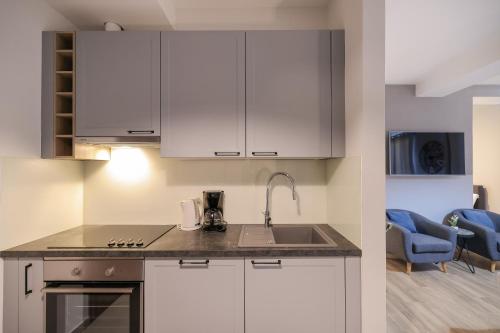 a kitchen with white cabinets and a sink at Elegance Studio Apartments in Zadar