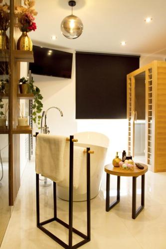 a bathroom with a bath tub and a table at Afrodita Wellness Essence in Plitvička Jezera