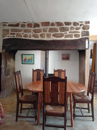 a dining room with a wooden table and chairs at Chez Ophélie in Saint-Bazile-de-Meyssac
