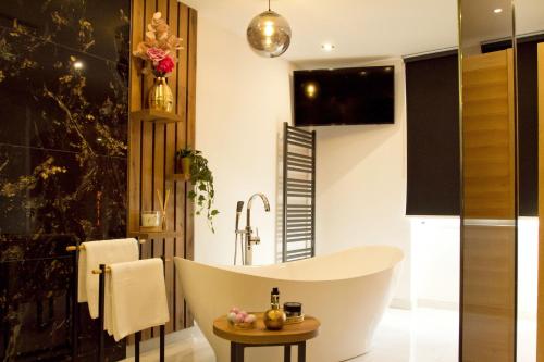 a bathroom with a bath tub and a table at Afrodita Wellness Essence in Plitvička Jezera
