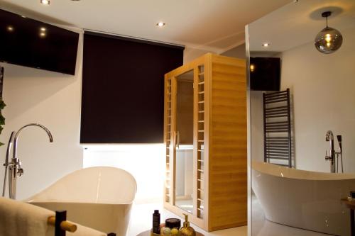 a bathroom with a tub and a mirror at Afrodita Wellness Essence in Plitvička Jezera